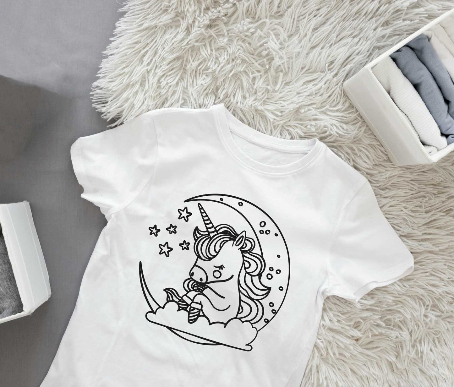 Ein T-Shirt mit einem Einhorn auf dem Mond und einem Stern, ideal als Ausmal-Bügelmotiv für kreative Köpfe.