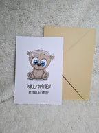 Eine herzliche Karte mit einem Teddybär, der "Willkommen in der Familie" ruft. Perfekt für neue Ankünfte!