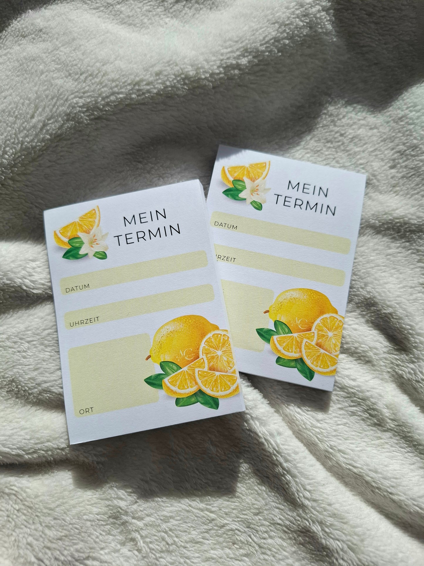 Handlicher A7-Notizblock mit Zitronendesign – perfekte Größe für unterwegs, gezeigt neben einem Kugelschreiber