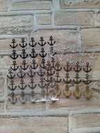 Eine Ansammlung kleiner Anker auf einer Ziegelmauer, die rustikalen Charme und maritimes Flair vermittelt.