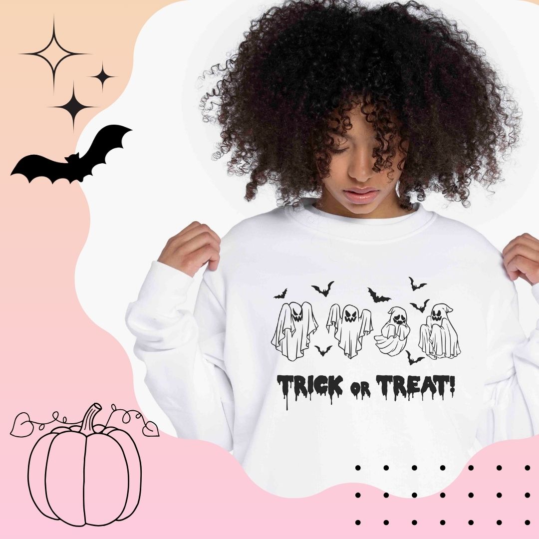 Eine Frau trägt einen weißen Sweatshirt mit der Aufschrift "Trick or Treat" und lächelt fröhlich in die Kamera. Es sind 4 Geister und 7 Fledermäuse zu sehen.