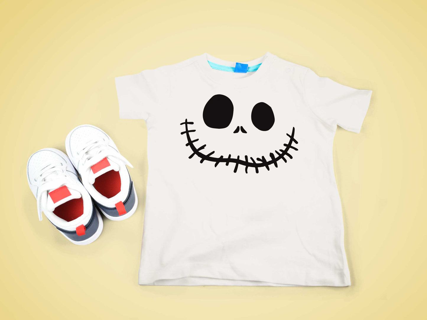 Kindershirt mit Jack Skellington-Motiv und Sneakers auf gelbem Hintergrund, ideal für Halloween und festliche Anlässe.