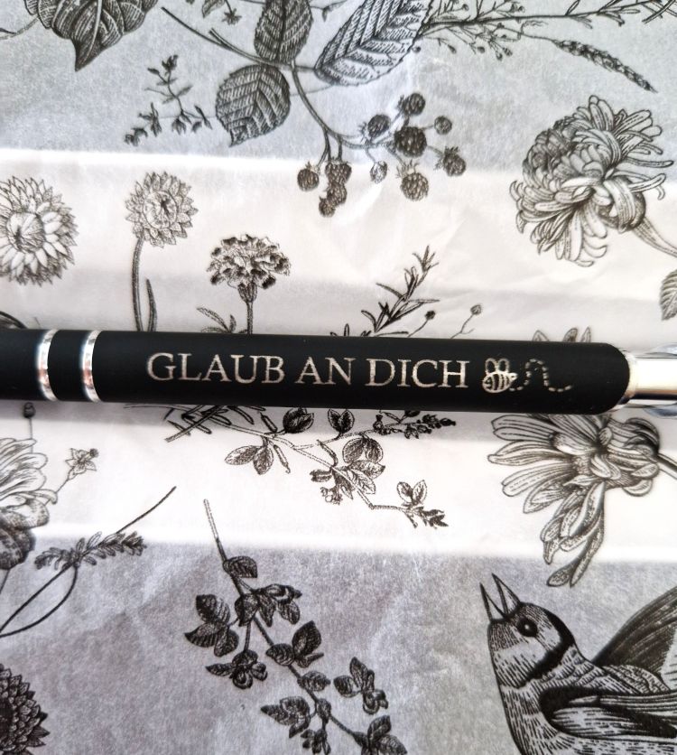 Nahaufnahme der Gravur „Glaub an dich“ auf hochwertigem Metall-Kugelschreiber mit individueller Personalisierung