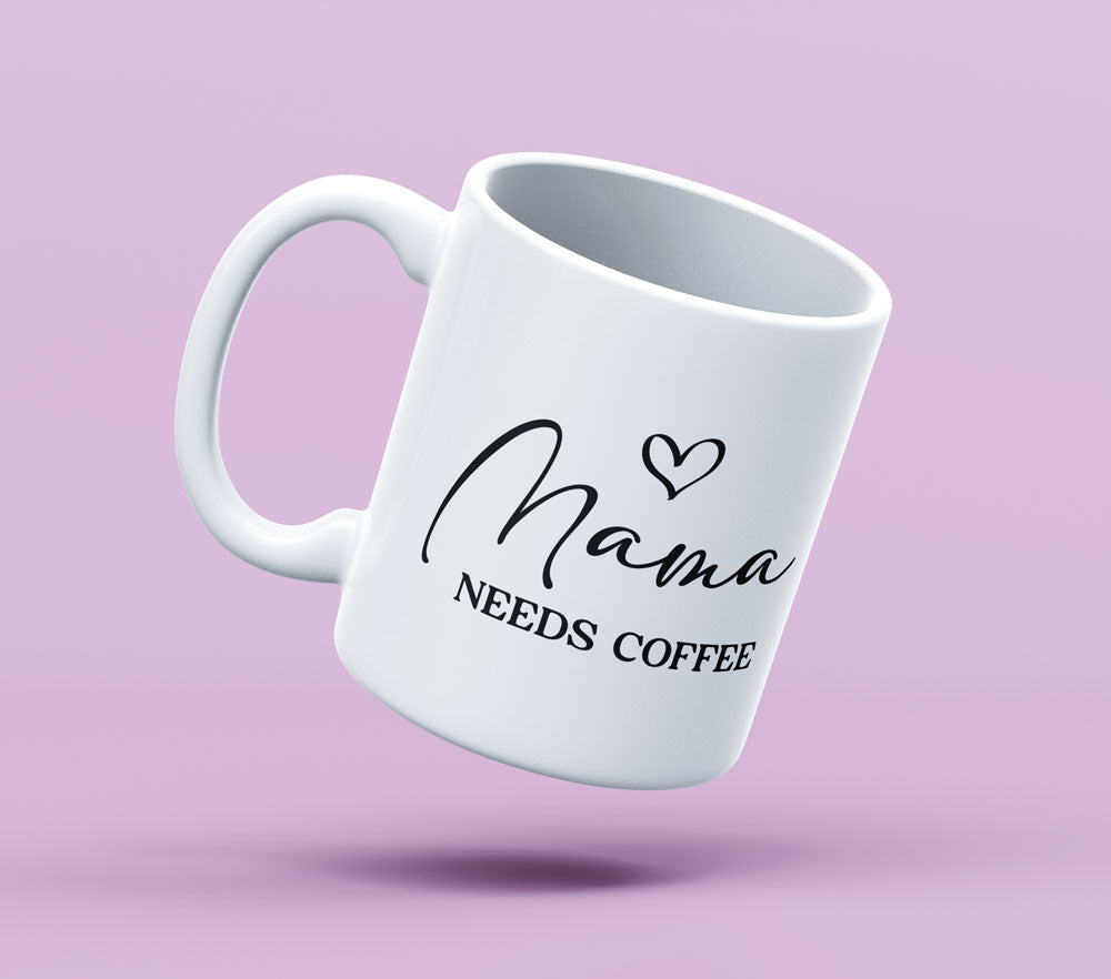 Auf einem hellrosa Untergrund ist eine weiße Tasse mit dem Schriftzug „Mama needs coffee“ und einem Herzsymbol platziert.