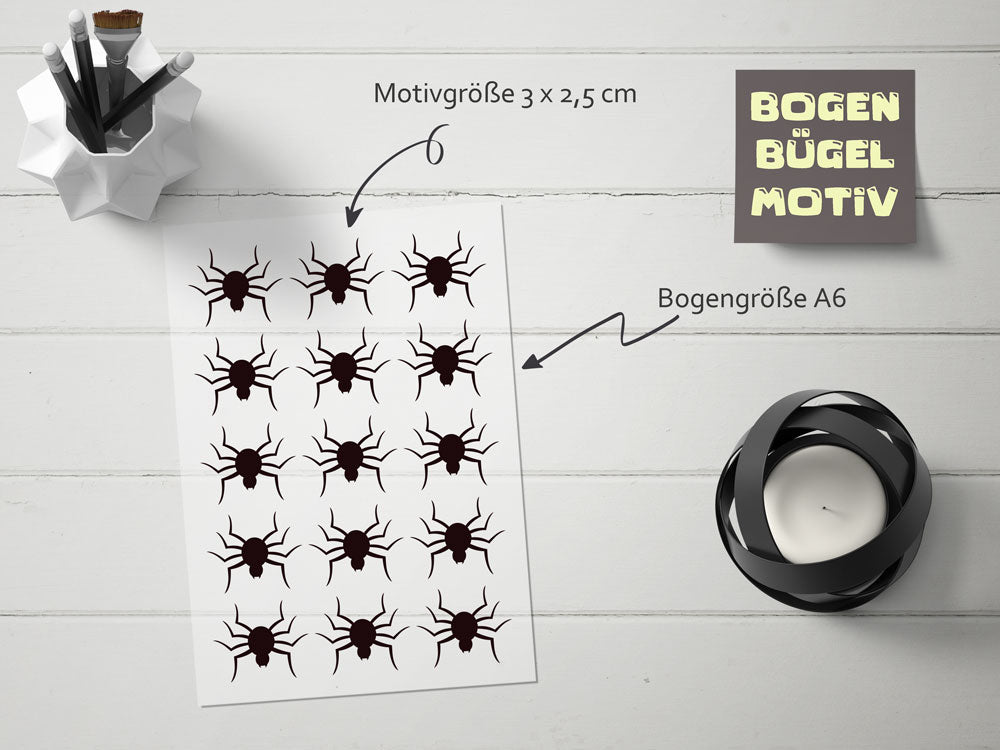 15 kleine Spinnen auf einem Bogen, die du selbst zuschneiden kannst und auf deine Kleidung selbst platzieren kannst.

A sheet with multiple black spider motifs is placed on a white surface, accompanied by a candle and a white container with black pencils, creating a Halloween vibe. Text indicates motif and sheet sizes.