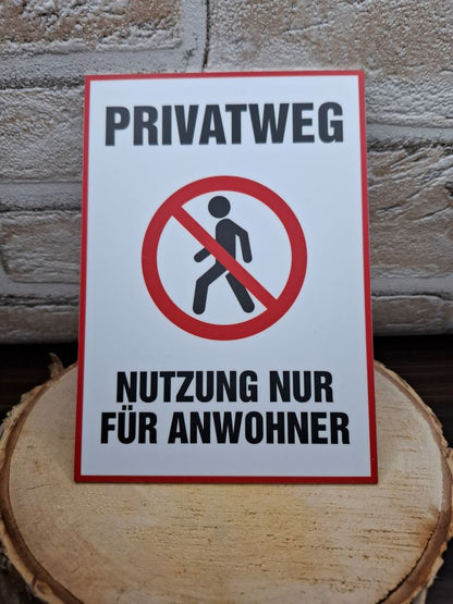 Ein Schild mit der Aufschrift "Privatweg" weist auf einen privaten Bereich hin.