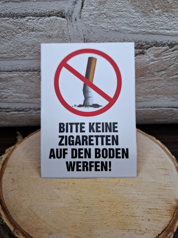 Ein deutliches Schild, das Rauchen verbietet und darum bittet, Zigaretten nicht auf den Boden zu werfen.